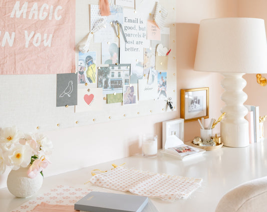 Our founder Chelsea's desk filled with a pinboard of inspiration, notepads, fabric swatches