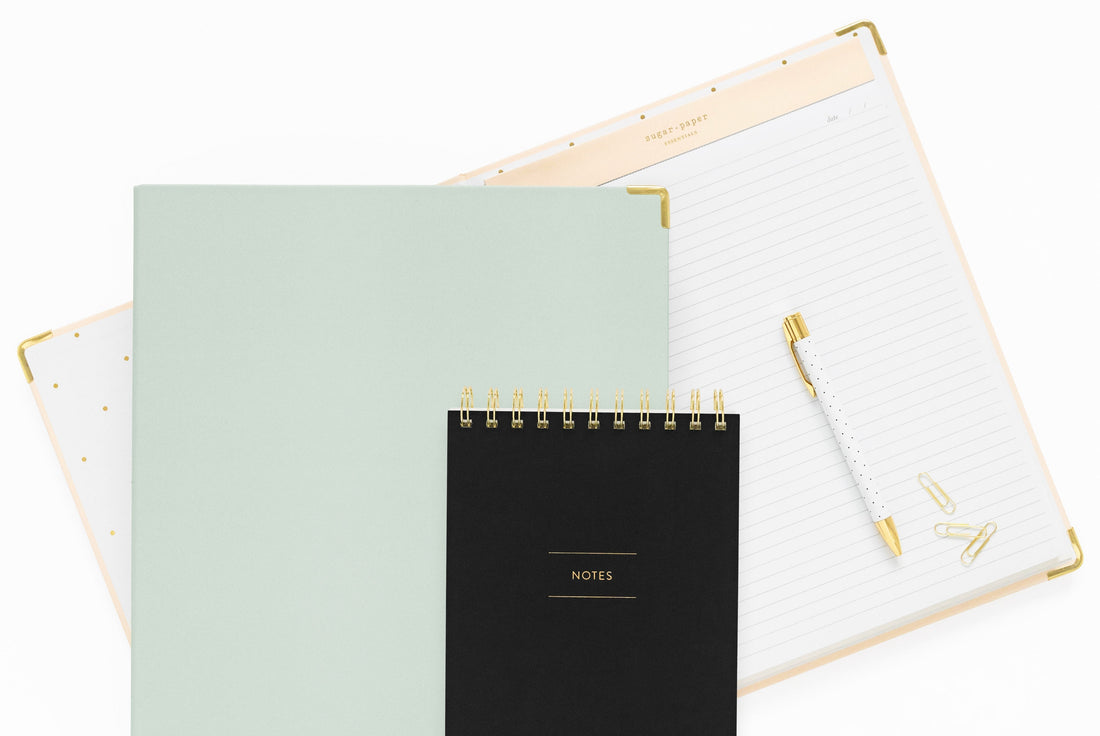 assorted office products in pink, mint green and black with gold accents