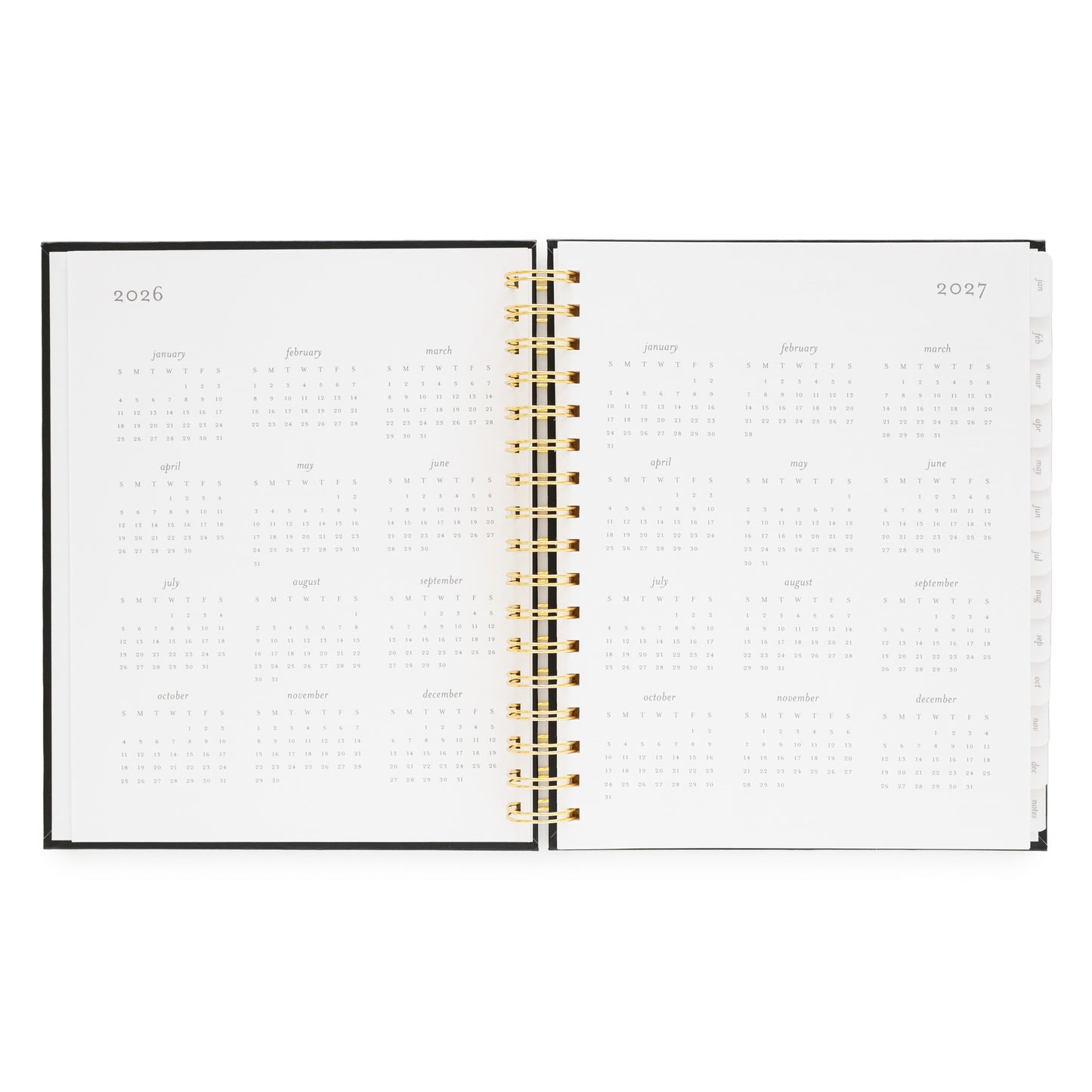 Open spiral planner with 2026 and 2027 calendar months with a gold spiral binding