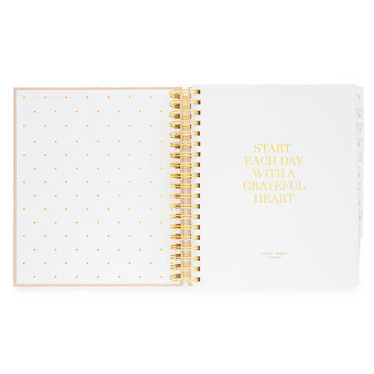 Open spiral planner with gold polka dot pages and 'Start Each Day With a Grateful Heart' printed in gold foil