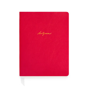 A red soft leather planner with gold foil script reading 'twenty-seven' on the front cover with white ribbon markers