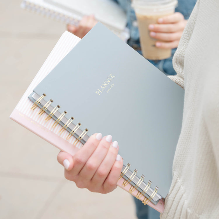 Person holding a spiral-bound academic planner