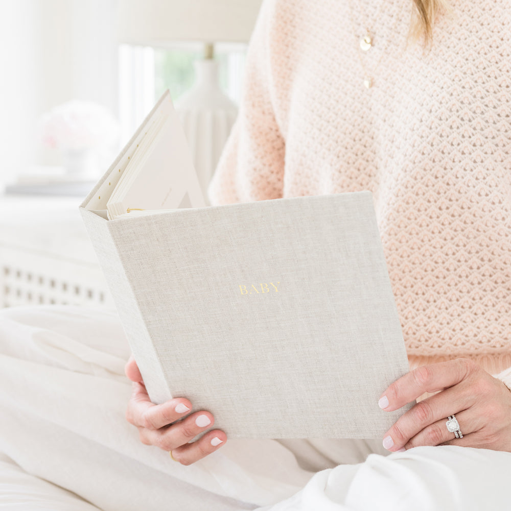 Baby Book in Flax Linen in Woman's Hands on Bed