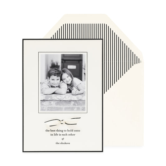 cream and black custom holiday card with ribbon detail and striped liner