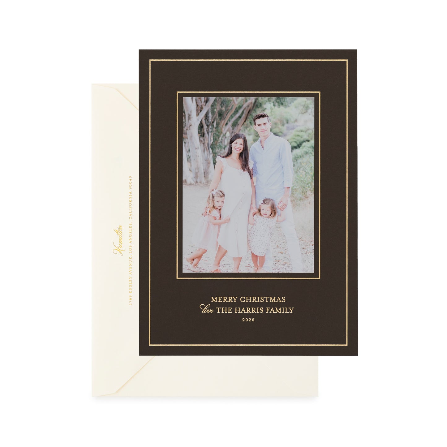A holiday photo card on dark chocolate paper with gold foil details, shown with a cream envelope.