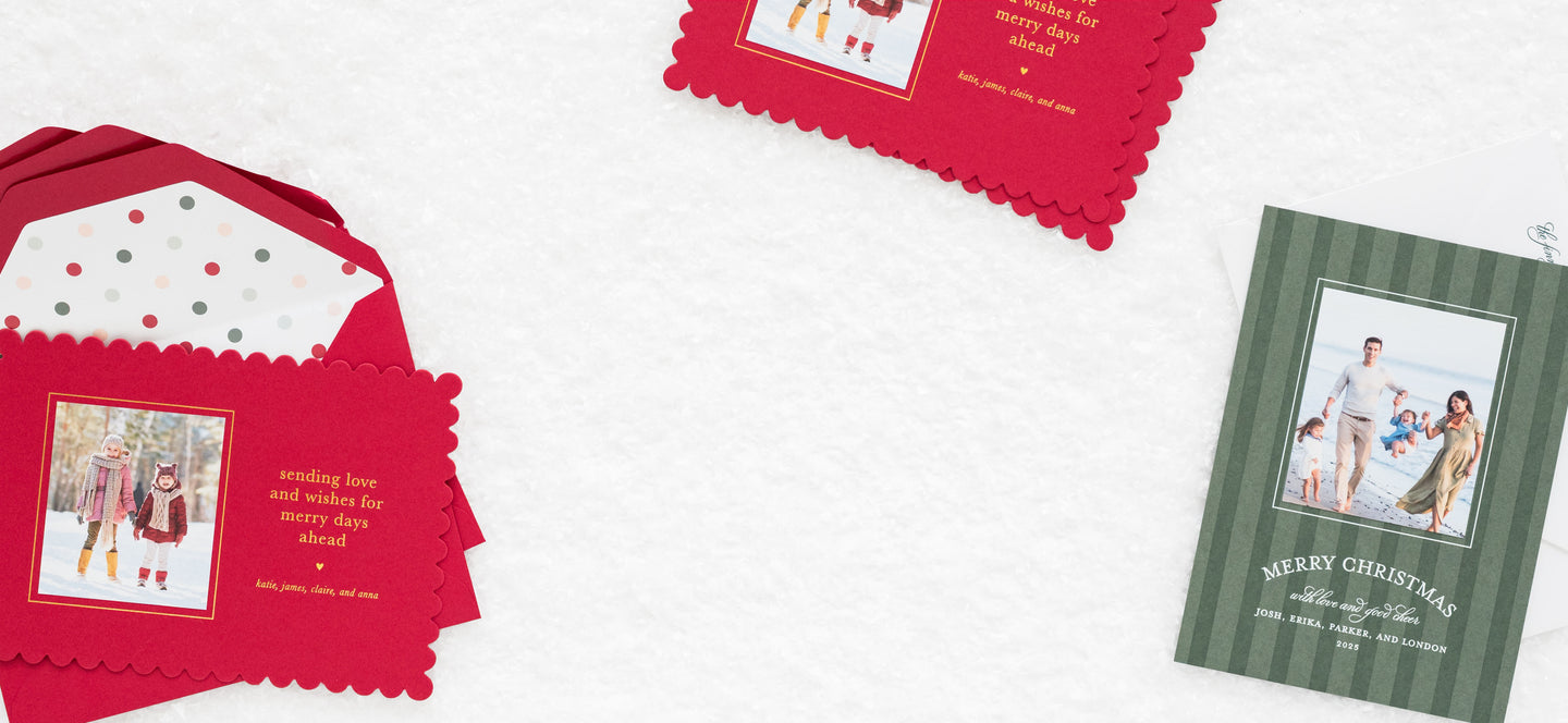 Stack of Christmas photo cards with red and green designs on a white background