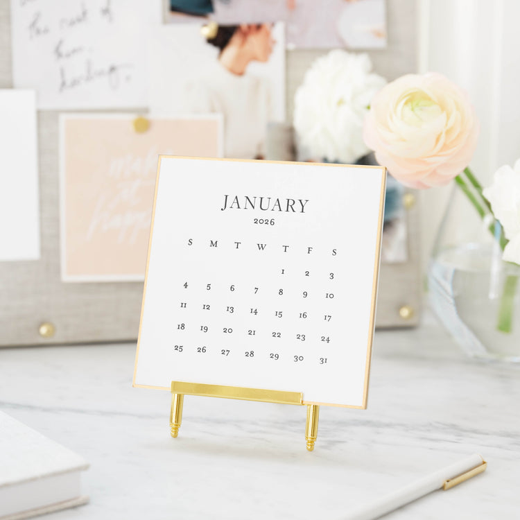 White month cards on a brass stand with black letterpress ink and a gold hand painted border