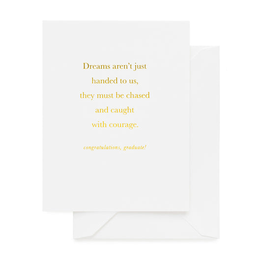 white graduation card printed with dreams aren't just handed to us, they must be chased and caught with courage. congratulations, graduate!