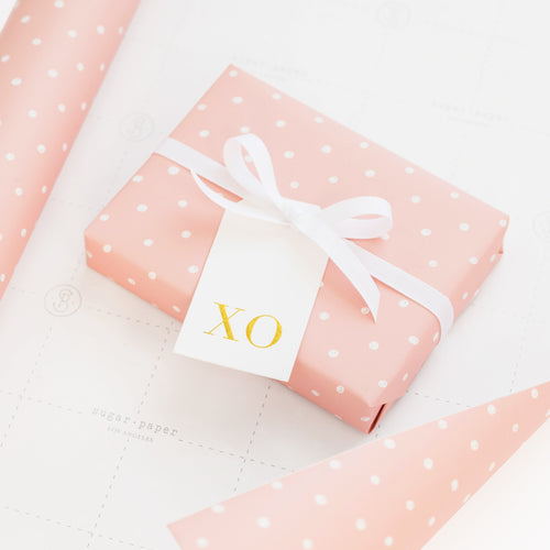 Rose and white dot wrapped gift with gold foil xo tag