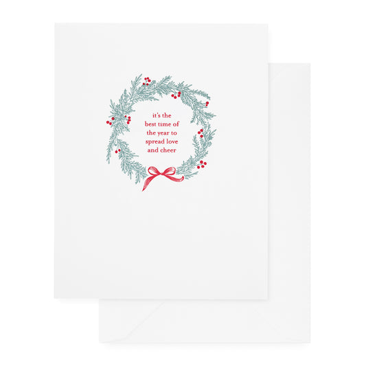 white holiday card with green wreath and red text and details