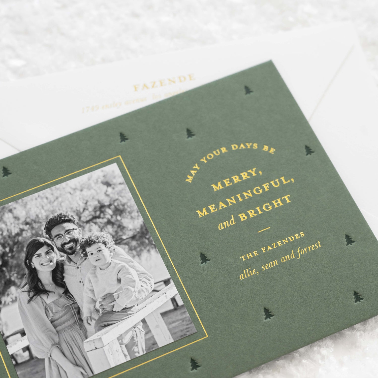 Close up of a green holiday card with green and gold printing.