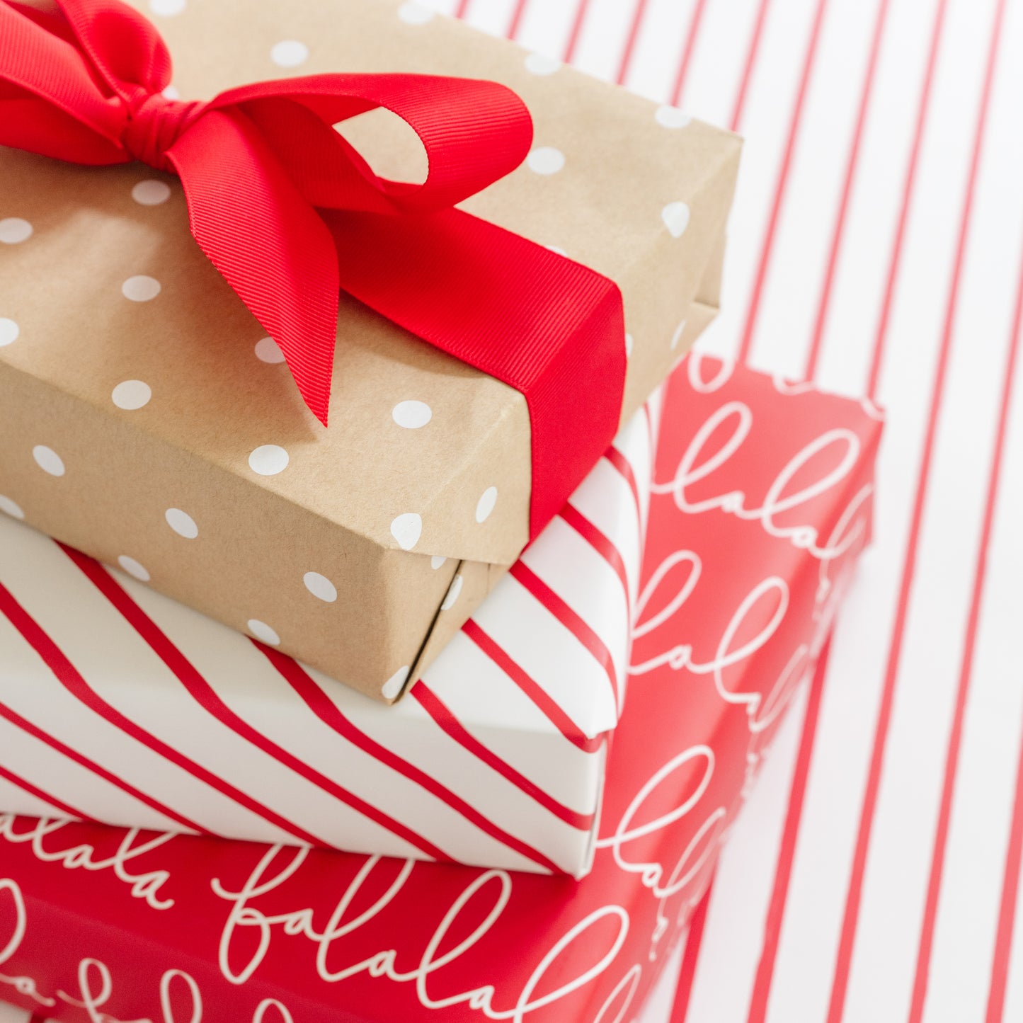 Stack of holiday wrapped kits on top of wrapping paper