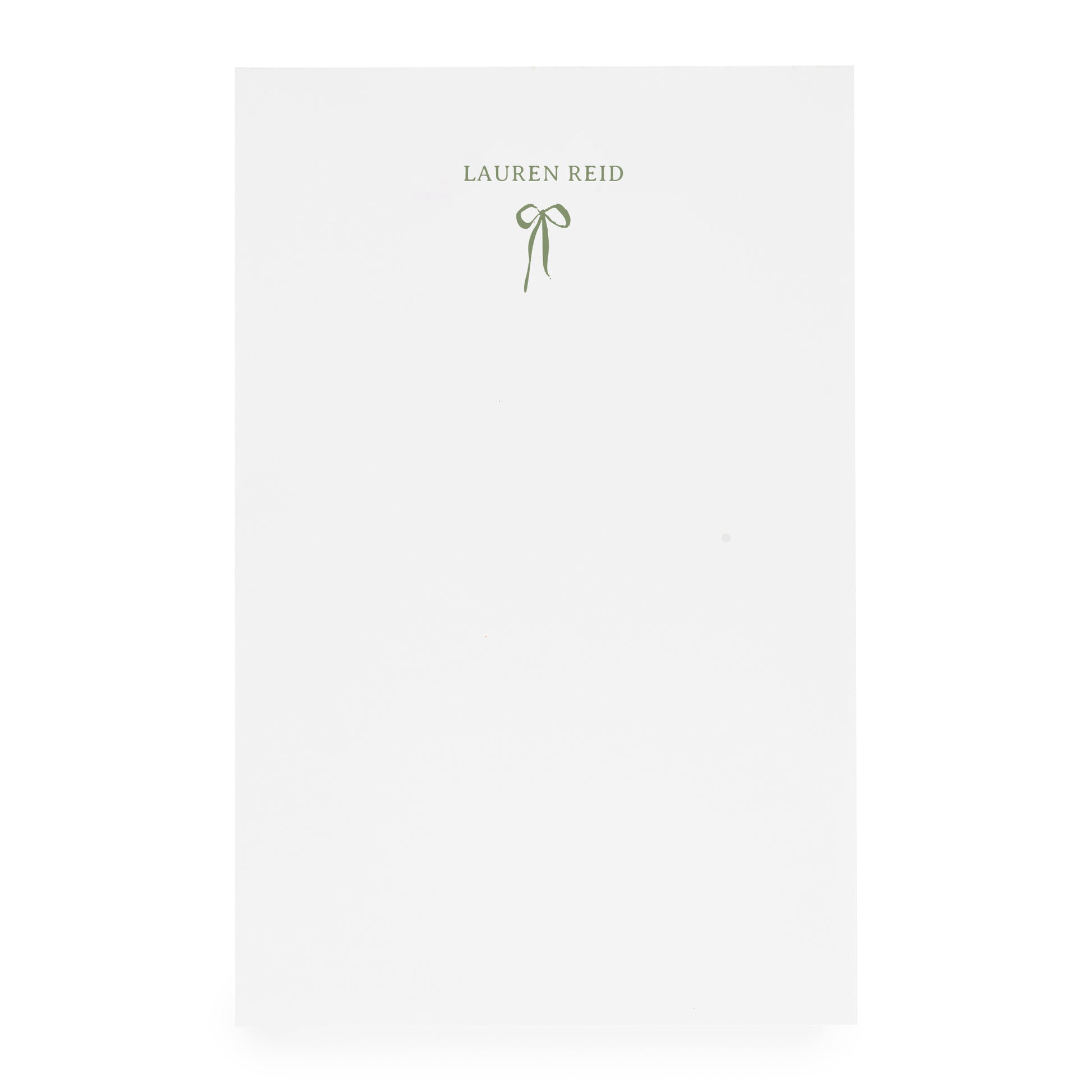 White notepad with ribbon bow and "lauren reid" in moss green ink