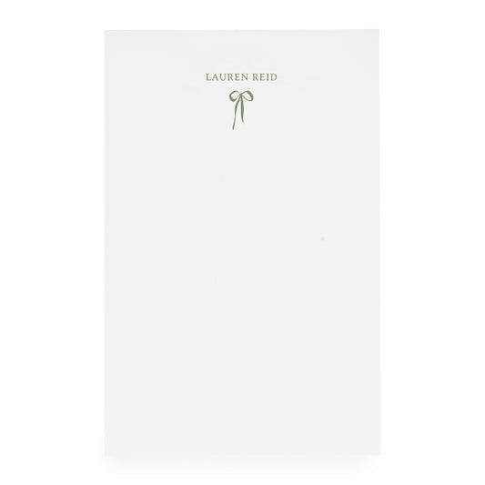 White notepad with ribbon bow and "lauren reid" in moss green ink