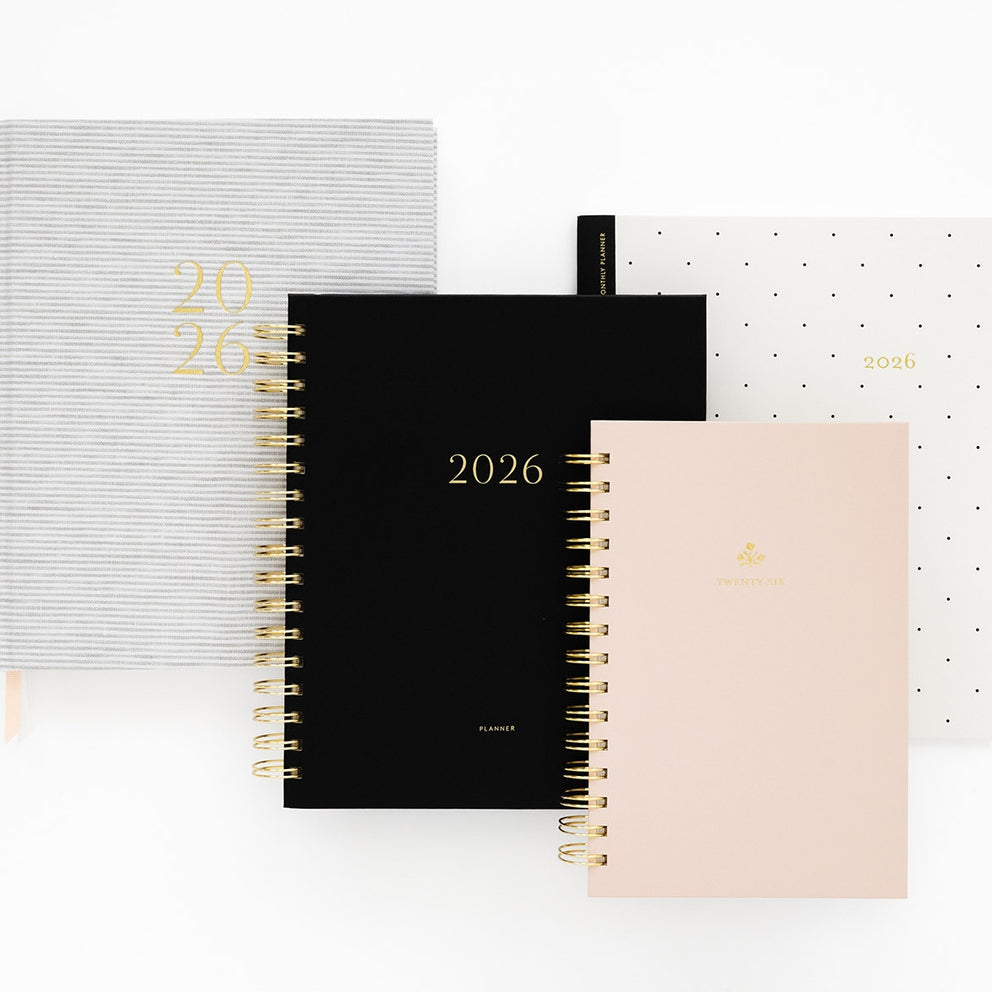 Four '2026' planners in grey stripe, black, pink and black dot styles