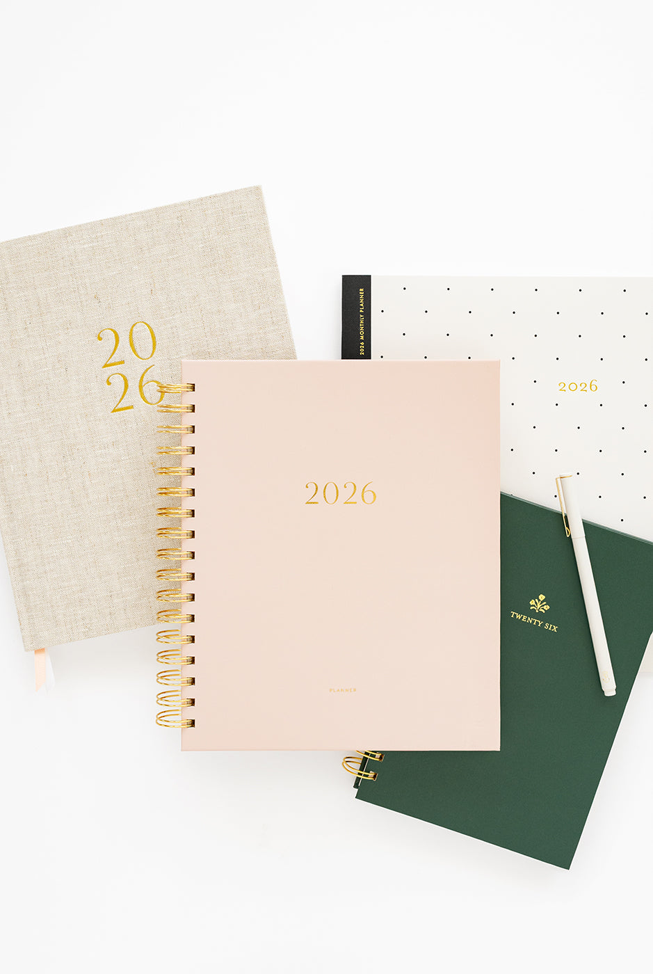 Collection of 2026 planners and a pen on a white background