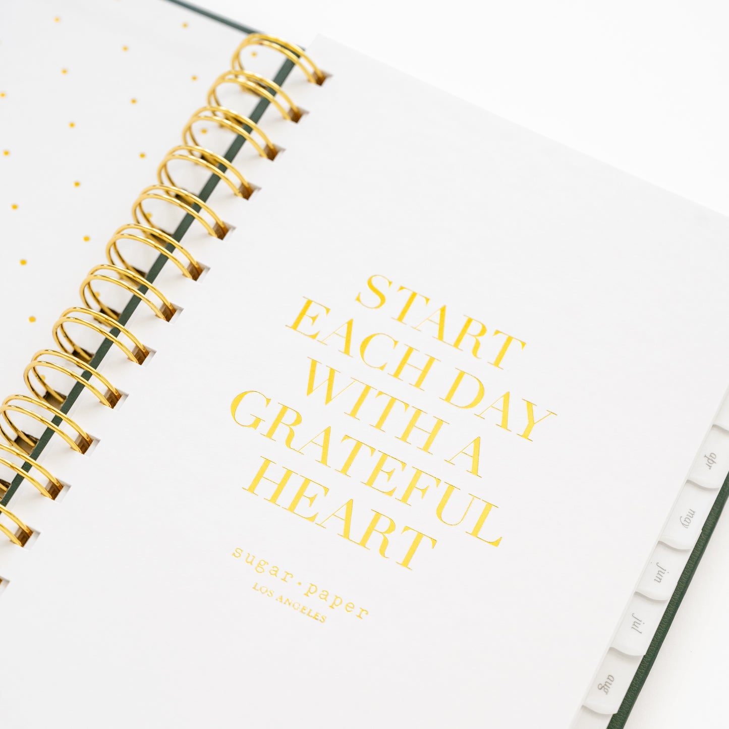 Closeup of small spiral planner quote page with 'start each day with a grateful heart'