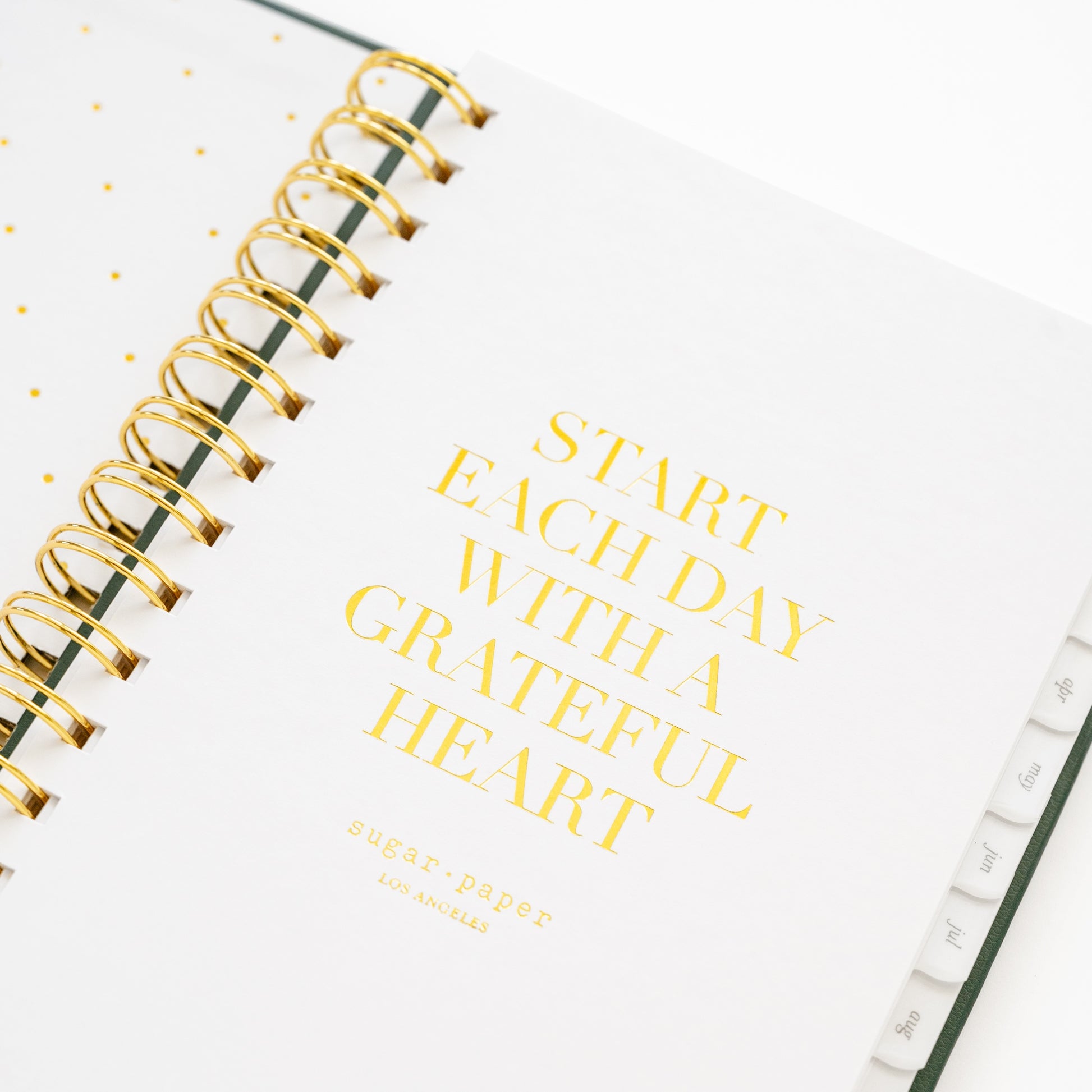 Closeup of small spiral planner quote page with 'start each day with a grateful heart'