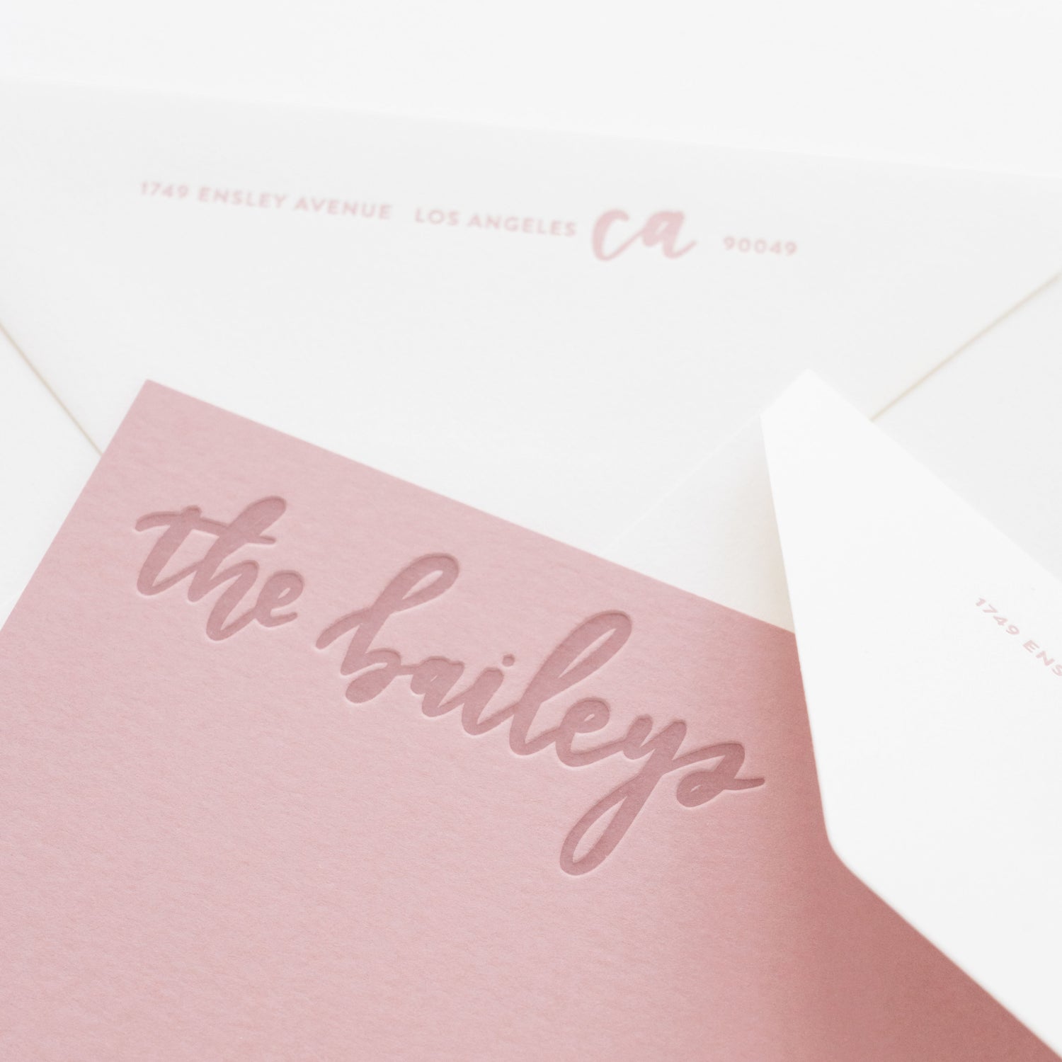 Pink stationery with 'the baileys' printed on it on a white background