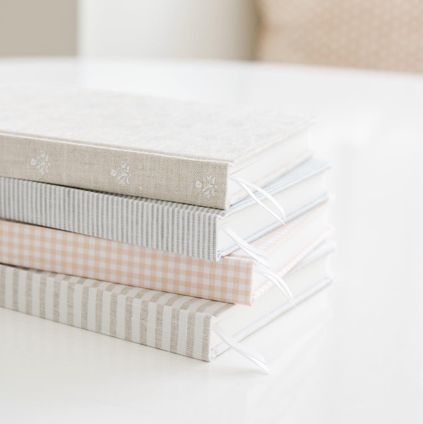 Stack of patterned fabric journals with white ribbon markers