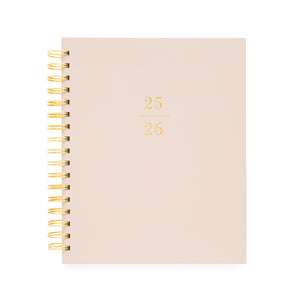 Dusty rose signature spiral planner with 25/26 on the cover in gold foil and a gold spiral binding