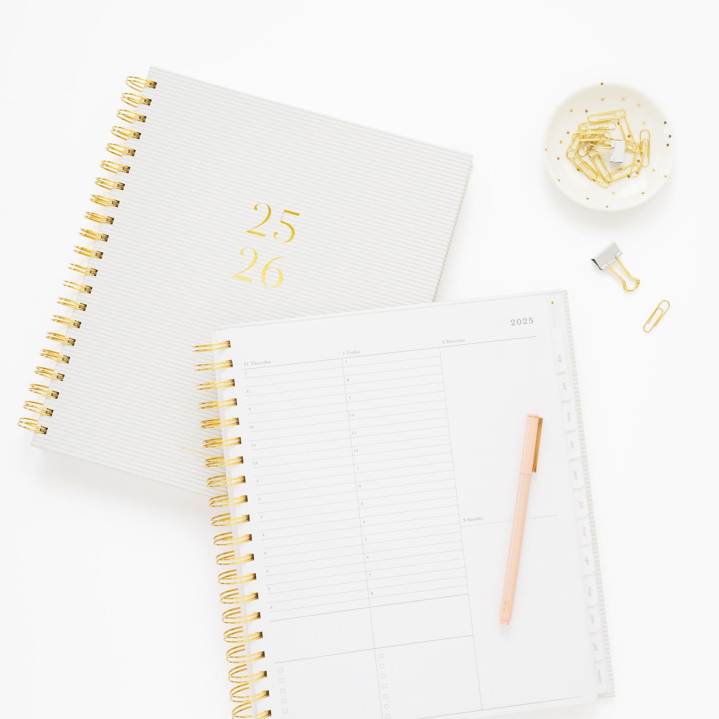 spiral 25-26 academic planner 1 closed 1 open to hourly daily page, with pen and paper clips