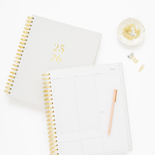 spiral 25-26 academic planner 1 closed 1 open to hourly daily page, with pen and paper clips