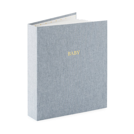 chambray fabric baby book book open standing up foil stamped with baby in gold on the cover