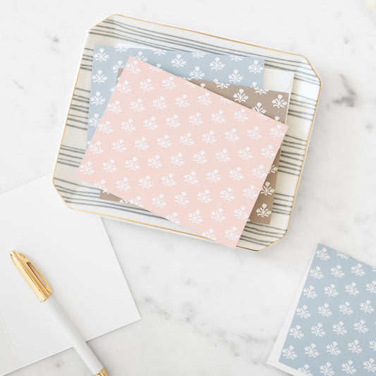 assorted floral notesets on a tray in pink, brown, and blue