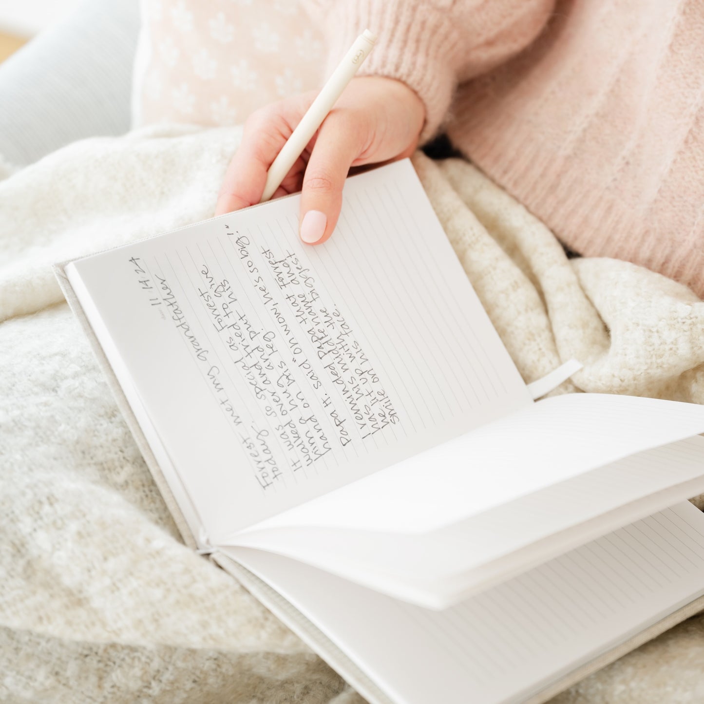 lined fabric journal open on lap with writing inside