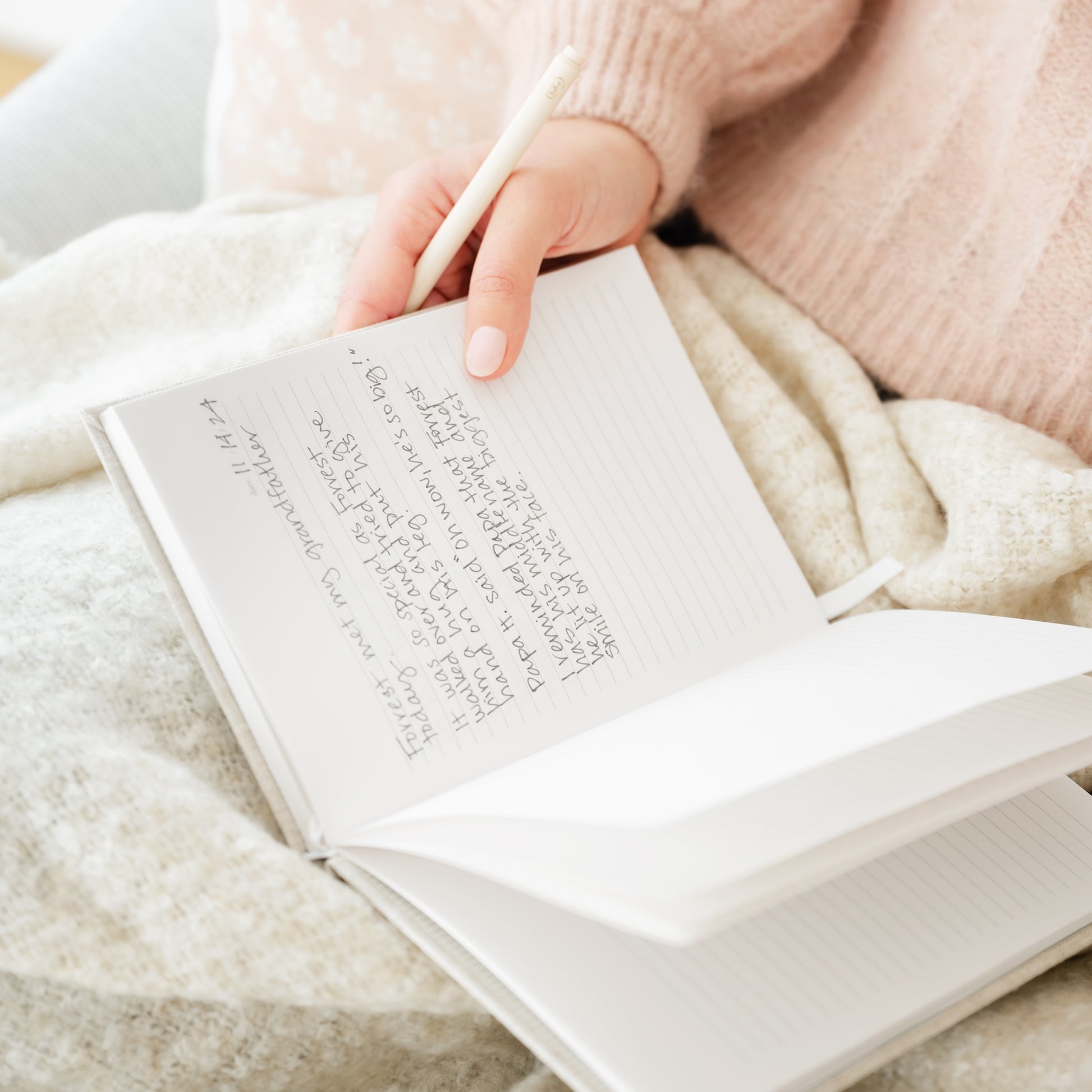 lined fabric journal open on lap with writing inside