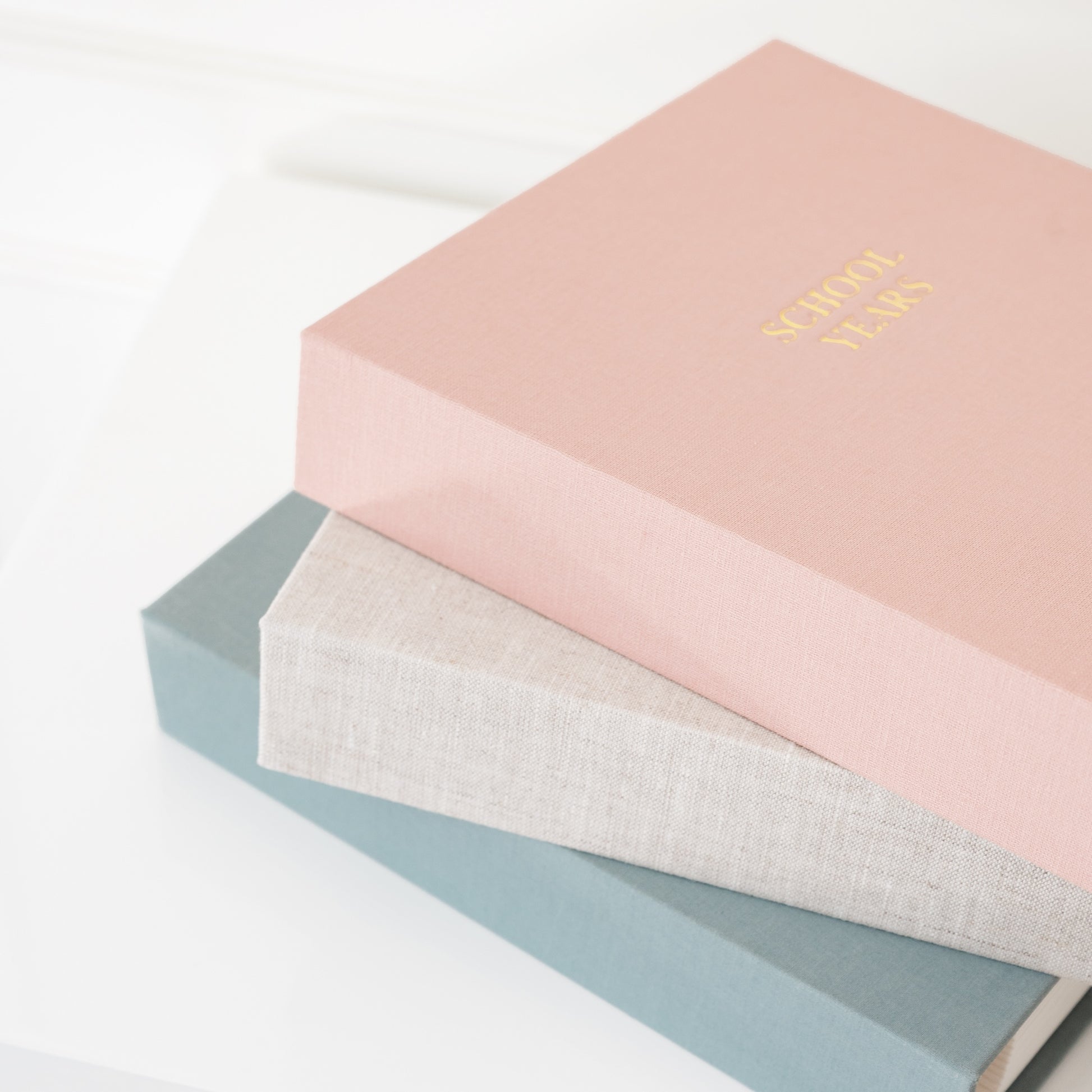 stack of school years books in blue, flax, and rose