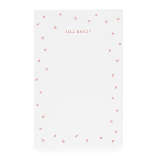 White notepad with scattered star bordered and 'ella bailey' text in rose ink