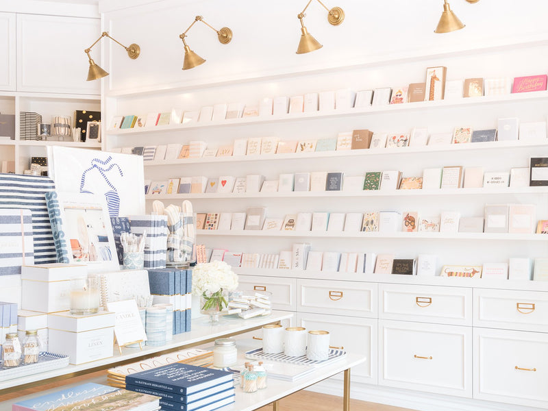 Interior shot of Sugar Paper's Newport Beach store featuring merchandising and wall full of greeting cards