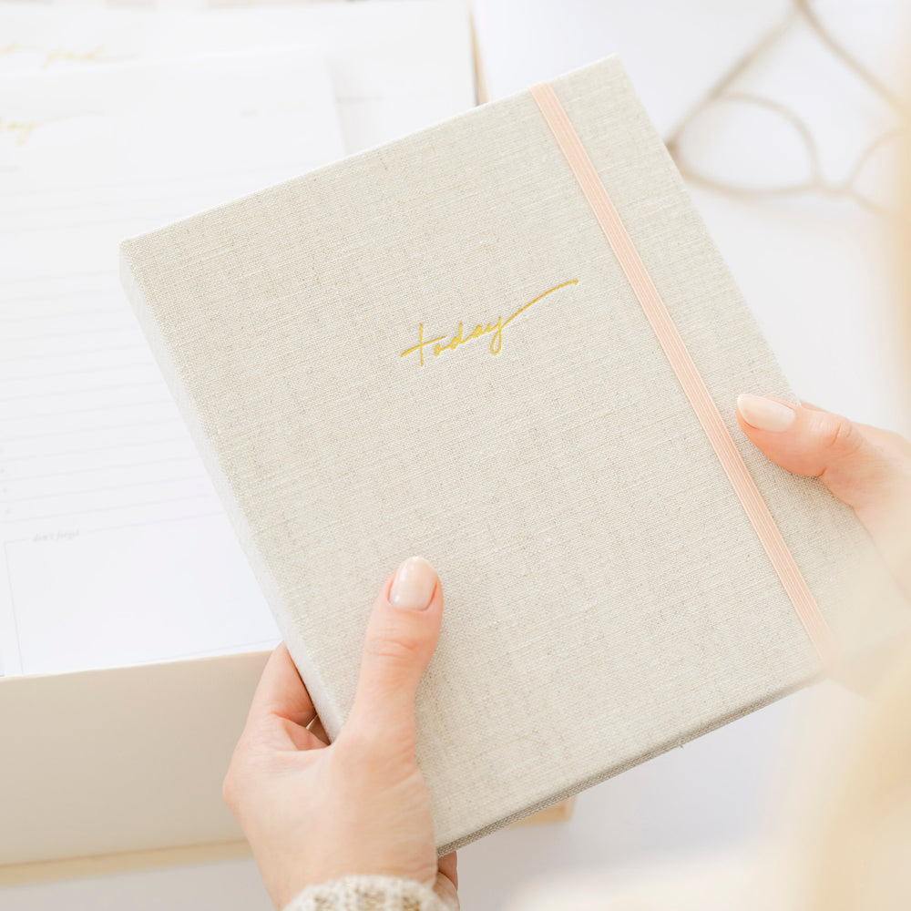 Woman holding mindful journal with gold foil today on front
