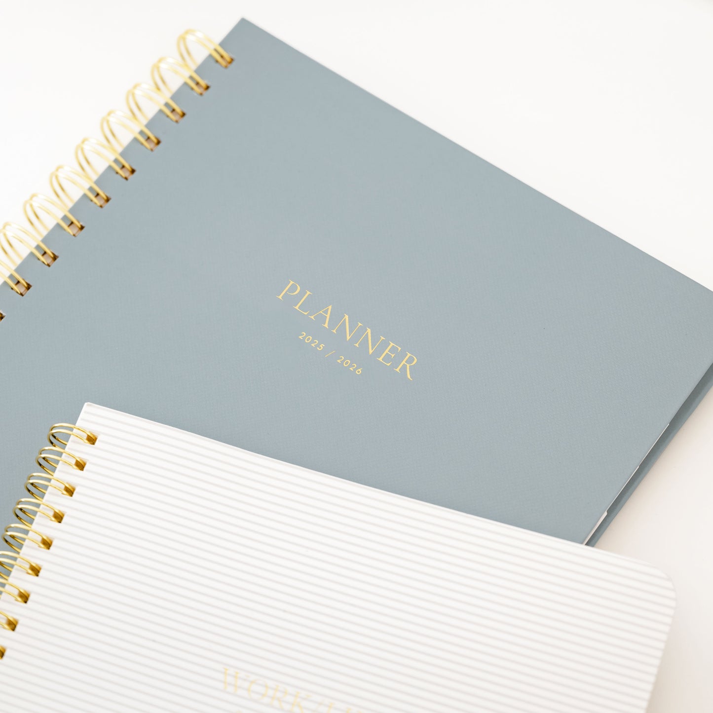 dusty blue spiral planner and grey striped notebook