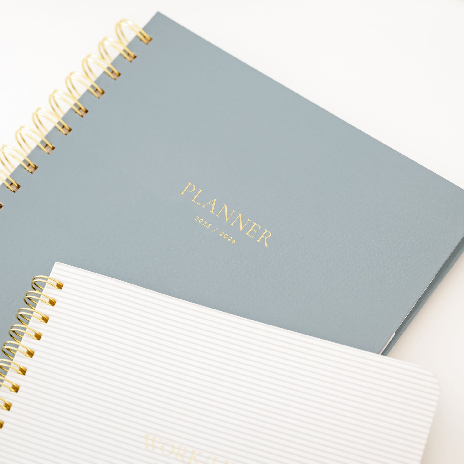 dusty blue spiral planner and grey striped notebook