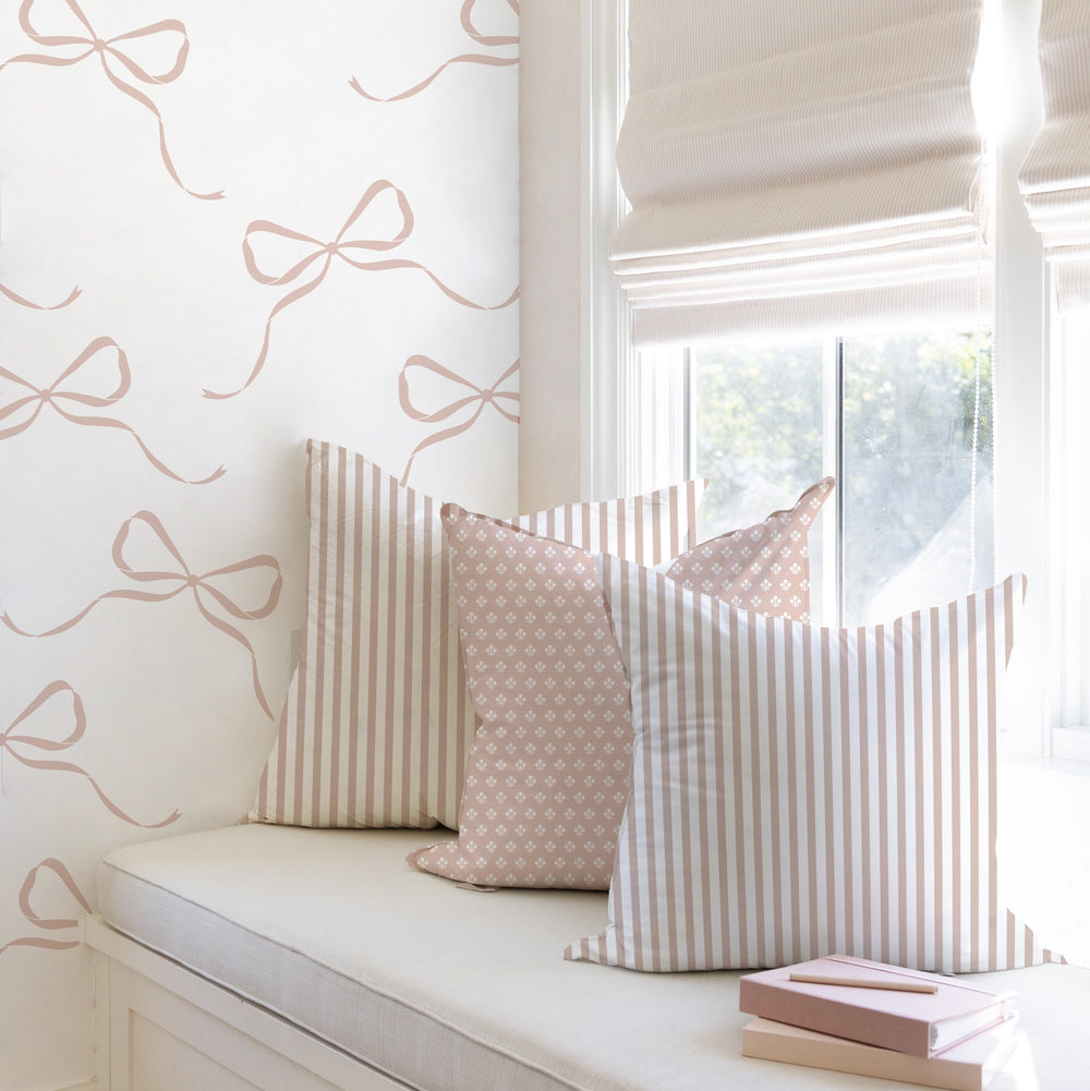 pillows on interior window bench with pink bow wallpaper