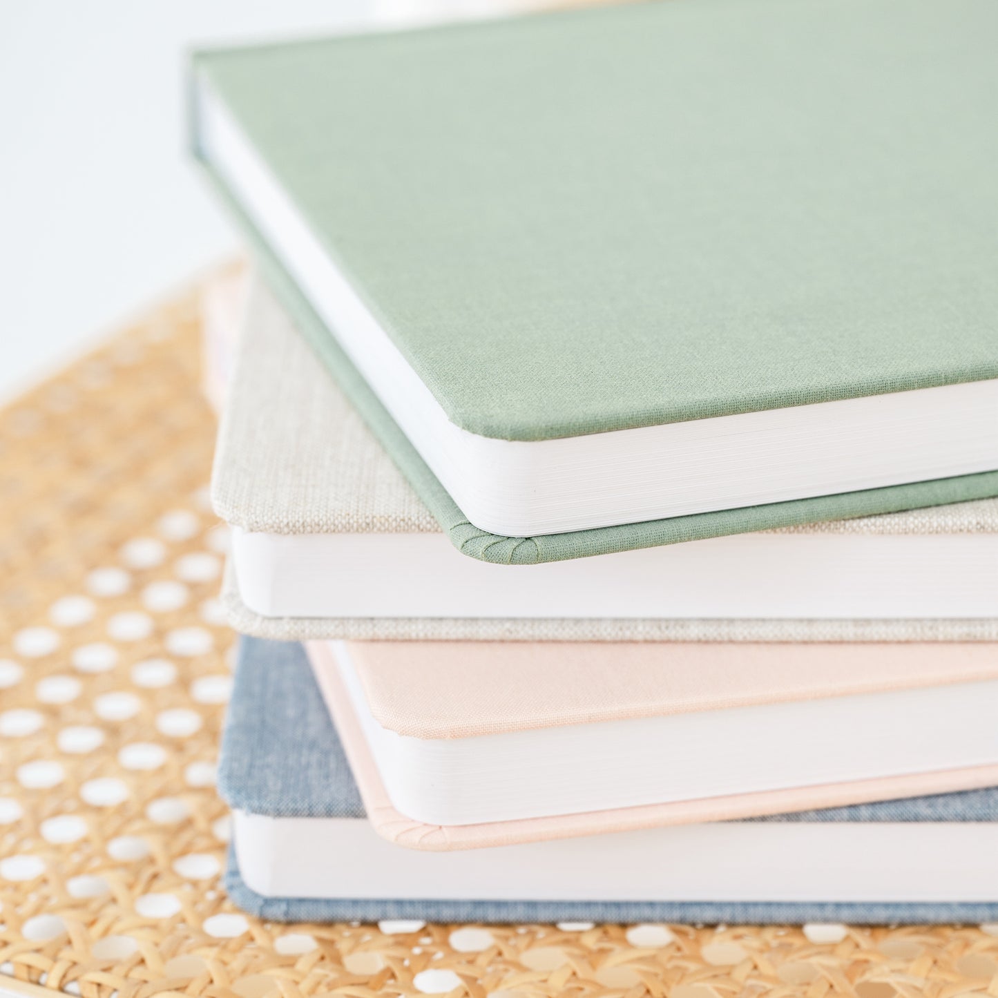 stack of fabric undated planners in green, flax, pale pink and chambray