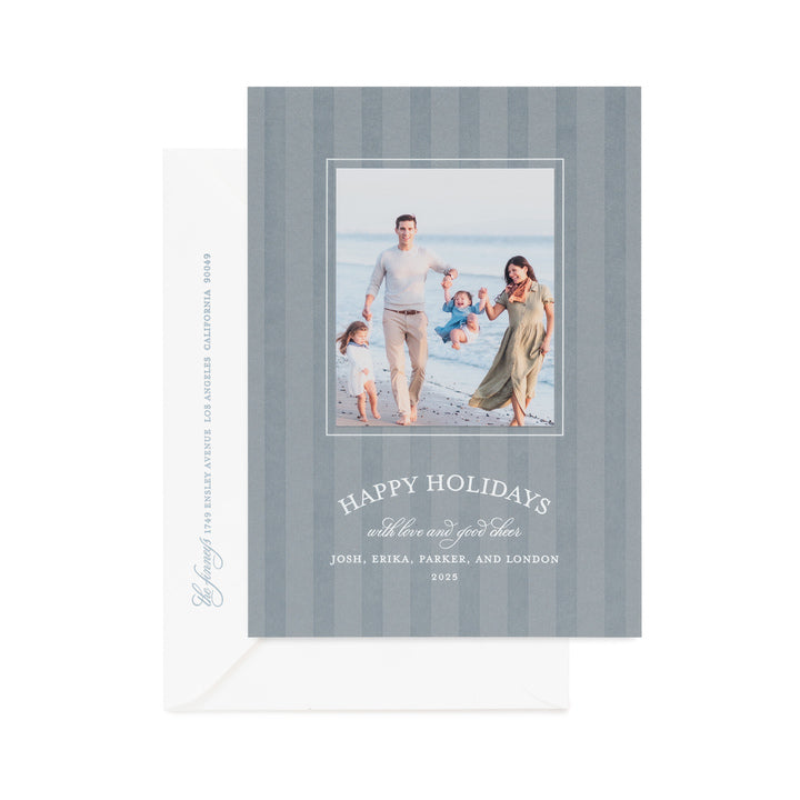 coastal blue custom holiday card with darker tonal letterpress printed blue stripes with a photo of a family with white foil 'happy holidays with love and good cheer' paired a white envelope with blue ink return address