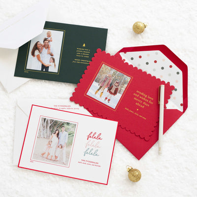 Set of holiday photo cards with envelopes on a white surface