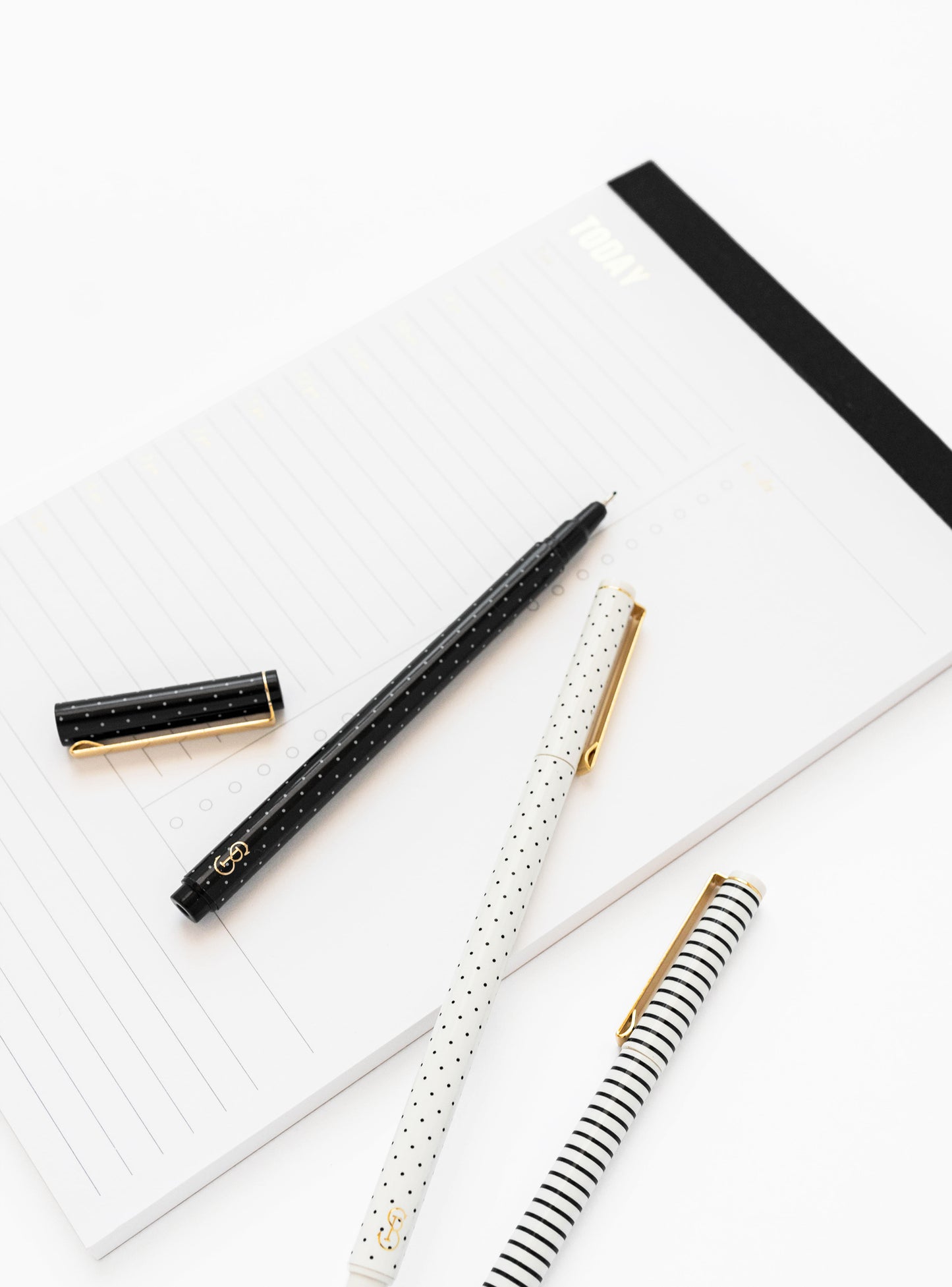 Black and white felt tip pens on black note pad