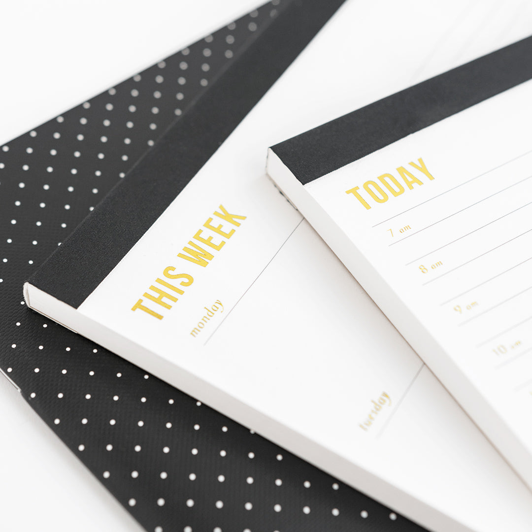 Close up details of this week and today black planning note pads.