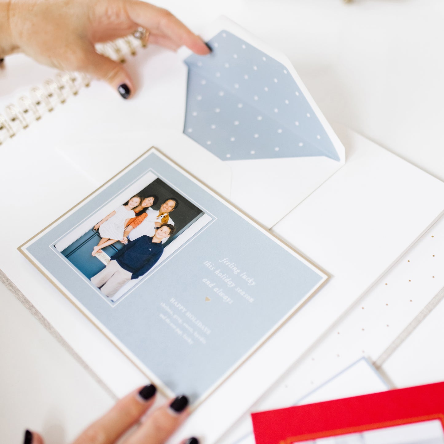 person adhering a holiday card into the holiday card book