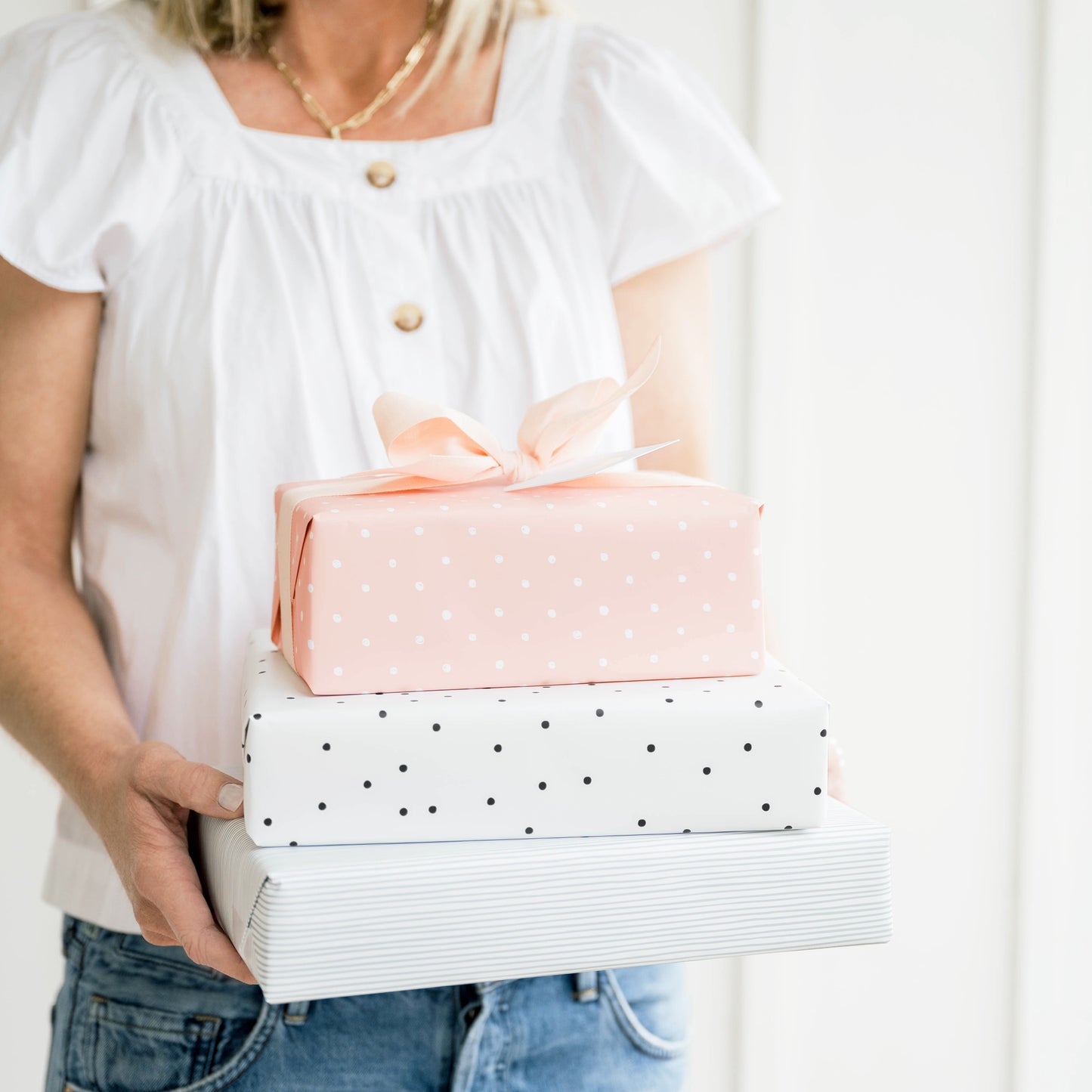 Woman holding stacked wrapped gifts