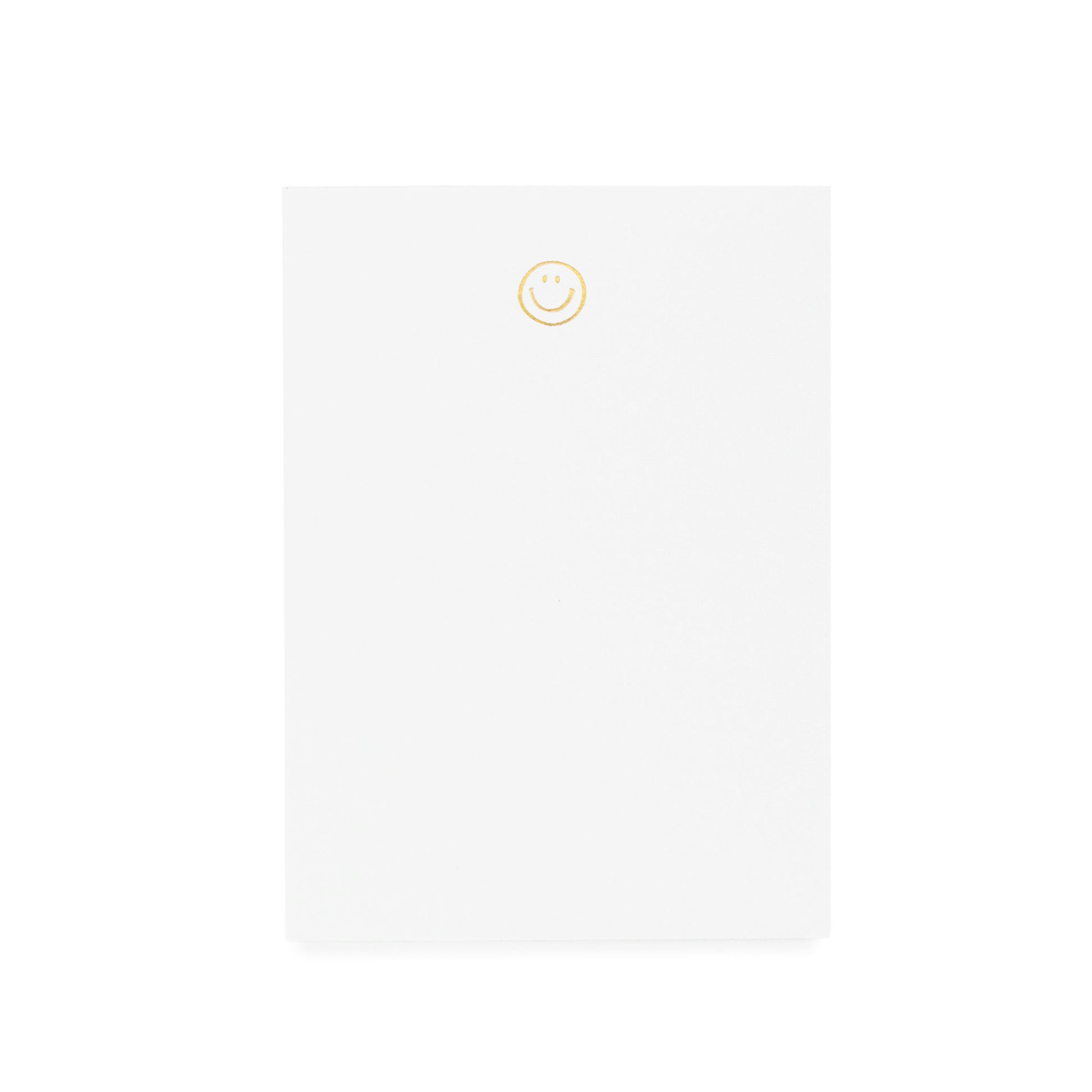 White notepad printed with gold foil smiley