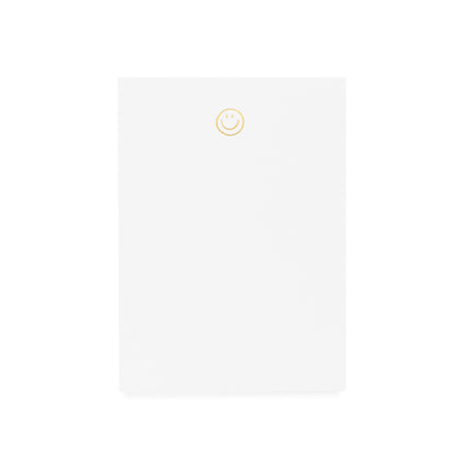 White notepad printed with gold foil smiley
