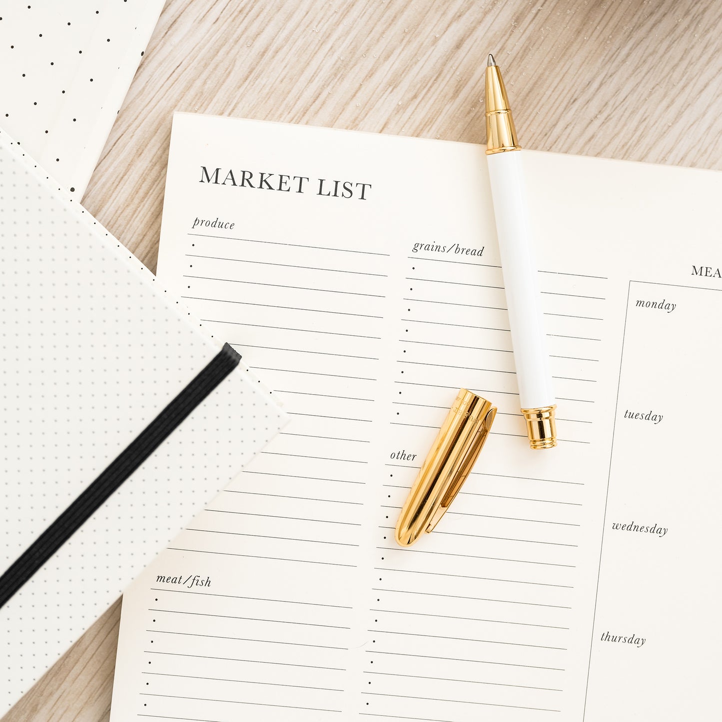 market list with pen and recipe book on counter