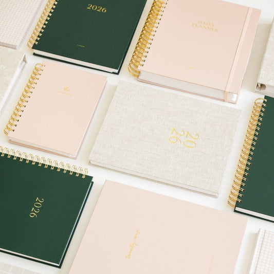 A neat arrangement of multiple planners laid out side by side on a table.