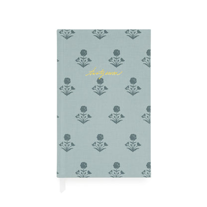Fabric bound agenda with a dusty blue fabric and dark blue floral pattern with 'twenty-seven' foil stamped on the cover with two white ribbon markers